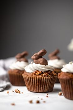 several cupcakes with white frosting and chocolate bunny ears