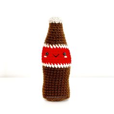 a crocheted bottle with a face on it