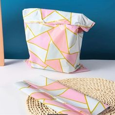 a pink and white bag sitting on top of a table next to a wicker basket