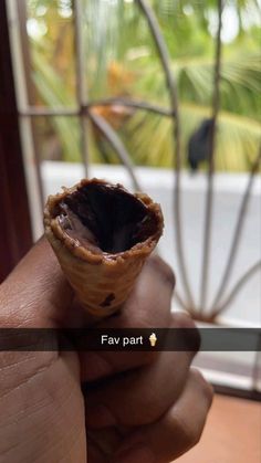 a person is holding an ice cream cone in front of a window with the words fav part on it