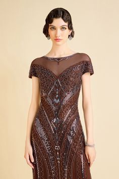 The see-through neckline exudes allure, perfectly complemented by the geometric pattern embroidery that sparkles with captivating radiance, like stars in a midnight sky. The dress's delicate cap sleeves add a touch of elegance, framing your shoulders with grace. Whether you're sipping champagne at a rooftop soirée or twirling on the dance floor at a gala, this dress is a true showstopper. Features: See-through neckline Intricate geometric pattern embroidery Sparkling beads for captivating radian Evening Dress With Illusion Neckline And Cap Sleeves, Fitted Cap Sleeve Evening Dress For Gala, Fitted Bodice Cap Sleeve Evening Dress For Party, Festive Short Sleeve Evening Dress For Gala, Fitted Sequined Evening Dress With Short Sleeves, Fitted Evening Dress With Illusion Neckline And Short Sleeves, Festive Fitted Evening Dress With Short Sleeves, Festive Short Sleeve Sequin Dress, Fitted Short Sleeve Evening Dress For Festive Occasions