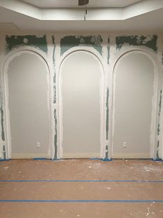 an empty room with three arches painted on the wall