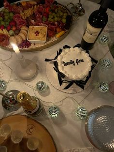 a table topped with a cake and wine bottles