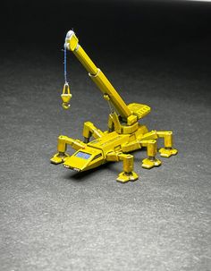 a yellow toy crane sitting on the ground