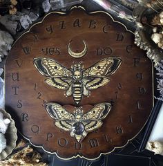 a wooden clock with moths on it