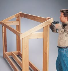 a man is working on the framing of a wooden frame for a dollhouse house