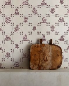 a piece of wood sitting on top of a wooden shelf next to a wallpaper