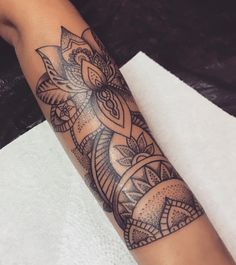 a woman's arm with an intricate tattoo design on the left forearm and wrist