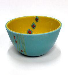 a blue and yellow bowl sitting on top of a white table