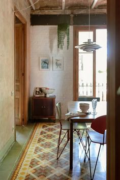 a dining room with a table and chairs next to a doorway that leads into another room