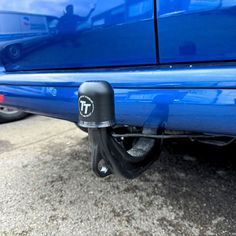 there is a blue car parked on the street with it's door handle up