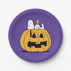 a purple paper plate with a cartoon pumpkin on it