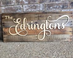 a wooden sign that says the edgingtons on it, sitting next to a brick wall