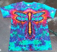 a tie - dyed t - shirt with a dragonfly design on the front and back