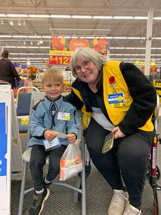 an older woman sitting next to a young boy in a shopping cart at a store