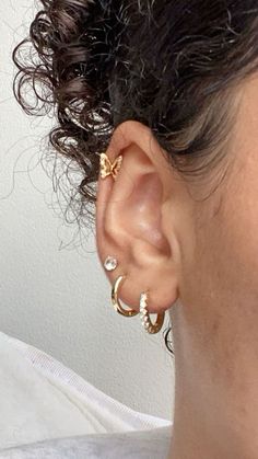 a close up of a person's ear with two small gold rings on it