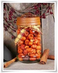 a jar filled with lots of nuts next to cinnamon sticks