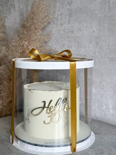 a white cake with gold ribbon and hello written on it