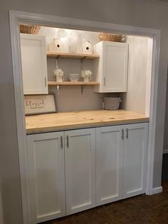 a kitchen with white cabinets and wooden counter tops