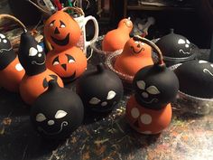 several pumpkins with faces painted on them sitting on a table next to other items