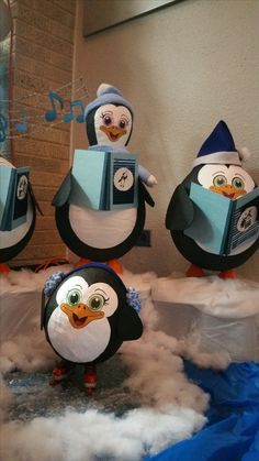 three penguins are standing in the snow with musical instruments on their heads and beaks