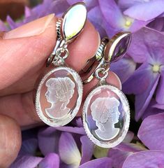 Pretty cameo-like earrings are set in a shiny silver tone setting. These clips have a dangling oval shaped cameo that is unique in that they are a frosted cameo of a lady cut into a clear background.   (see the backside of the cameo in  pic #10) These are very lovely Victorian style cameo earrings. 1 1/2 inches from top to bottom and the cameo itself is 1/2 inch in width. Lovely vintage condition! Vintage Clip Earrings, Cameo Earrings, Cameo Jewelry, Clear Background, Vintage Clip, Earrings Vintage, Clip Earrings, Shiny Silver, Jewelry Vintage