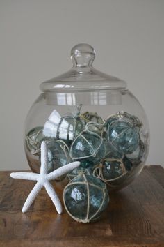 starfish and sea glass ornaments in a bowl on a wooden table with a lid