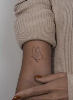 a woman's arm with a small tattoo on it