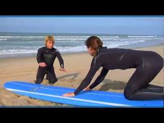 two people in wetsuits are on the beach