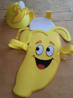 a yellow banana with a hat on it's head sitting on a wooden floor