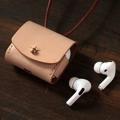 an earphone and case sitting on top of a wooden table