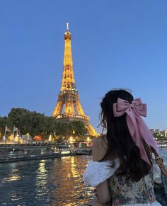 a woman sitting on a bench looking at the eiffel tower