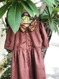 Brown linen dress with hand embroidered motifs on the peter pan collar.  ❤ Item description: - A lovely dress with hand embroidered mushroom, acorn, weeds and fern motifs. - Material: linen, coconut button, embroidery threads. - Very soft, skin friendly, breezy and comfortable. - Environmentally friendly. - This dress is very useful, go with any outfit, that can be used to go to school, go out, go shopping.    It is a perfect gift for yourself or your beloved.  ❤ Care instructions:      The best way to wash embroidery cloth is to put it in soapy water (with a mild detergent and cold water at 86 ºF/30oС) for 20 minutes. Try to not wash the item with other clothing that might cause damage, such as zippers, buttons or different colors. You wash it by hand, and if you have dirty patches on you Summer Embroidered Dress With Doll Collar, Fall Cotton Dress With Embroidered Hem, Cotton Fall Dress With Embroidered Hem, Fall Cottagecore Dress With Doll Collar, Cotton Dress With Embroidered Hem For Fall, Embroidered Cotton Dress With Doll Collar, Traditional Fall Dresses With Floral Embroidery, Cotton Embroidered Dress With Doll Collar, Traditional Floral Embroidered Dress For Fall