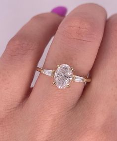 a woman's hand with a ring on it and a diamond in the middle