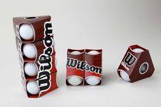 two boxes with balls in them sitting next to each other on a white table top