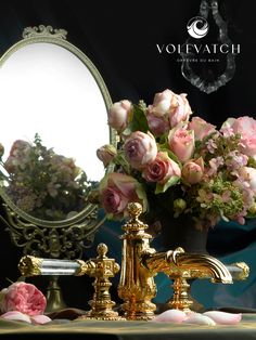 a sink with flowers in it next to a mirror and a vase filled with pink roses