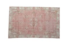 an antique rug with pink and white colors