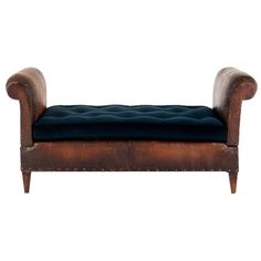 an antique leather bench with blue velvet upholstered seat