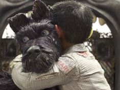 a man hugging a dog in front of a mirror