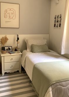 a bedroom with a bed, nightstand and pictures on the wall