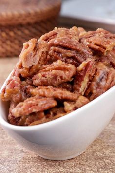 a white bowl filled with pecans on top of a table