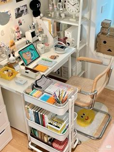 a white desk topped with lots of books next to a chair and shelves filled with items