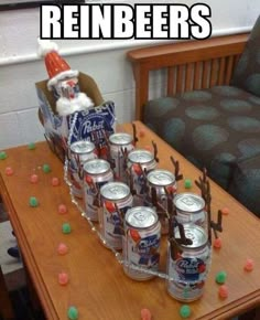 a wooden table topped with lots of cans of beer next to a christmas decoration on top of it