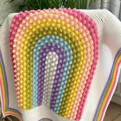 a crocheted blanket with a rainbow on it