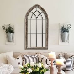 a living room filled with furniture and flowers on top of a coffee table in front of a window