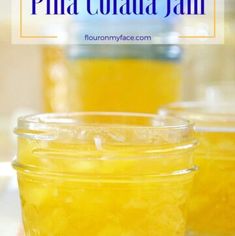 two jars filled with yellow liquid sitting on top of a table