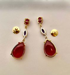 For Sale on 1stDibs - Red and purple colors glow in these statement dangle earrings. Brightly colored cabochon rhodolite garnet (origin: Tanzania) is complimented by richly Red Topaz, Diamond Red, Red And Purple, Rhodolite Garnet, Tanzania, Purple Color, Bright Colors, Garnet, Topaz