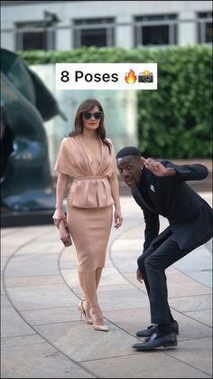 a woman in a dress and a man in a suit are on the sidewalk with their hands together