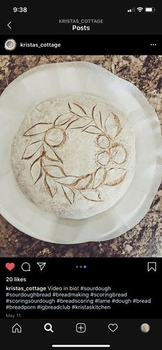 a cake sitting on top of a white plate covered in frosted icing and decorated with leaves