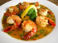 a close up of a plate of food with shrimp and garnish on it